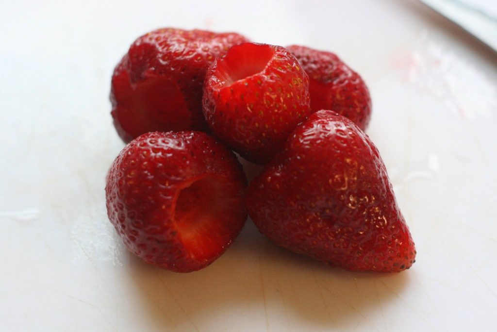 Hulled strawberries on a board. 