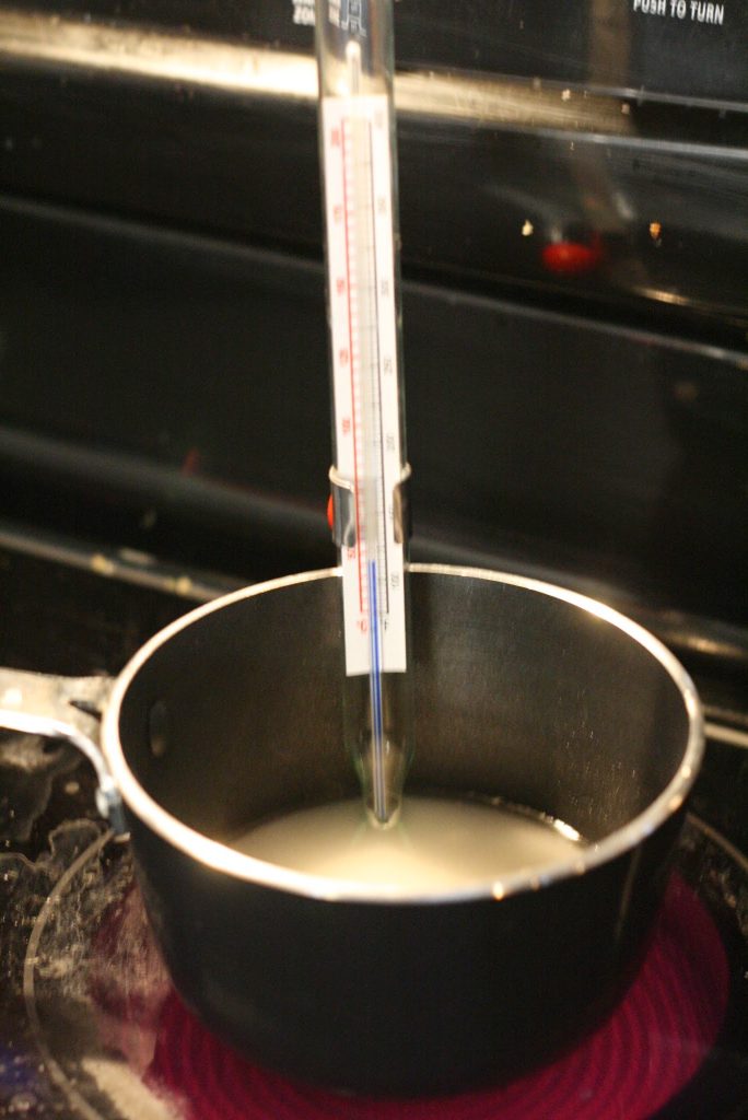 Sugar and water in a heavy bottomed pot. Candy thermometer on the side to measure the temperature.