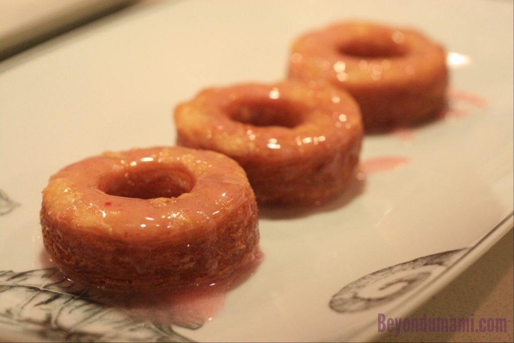Three Dinner With Julie Cronuts covered in strawberry glaze. Three Dinner With Julie Cronuts drizzled in strawberry glaze.