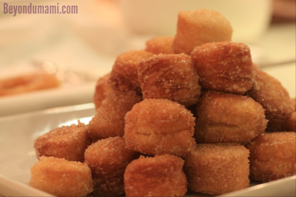 A pile of cronut holes or crobits sprinkled with sugar. A pile of cronut holes or crobits sprinkled with sugar.