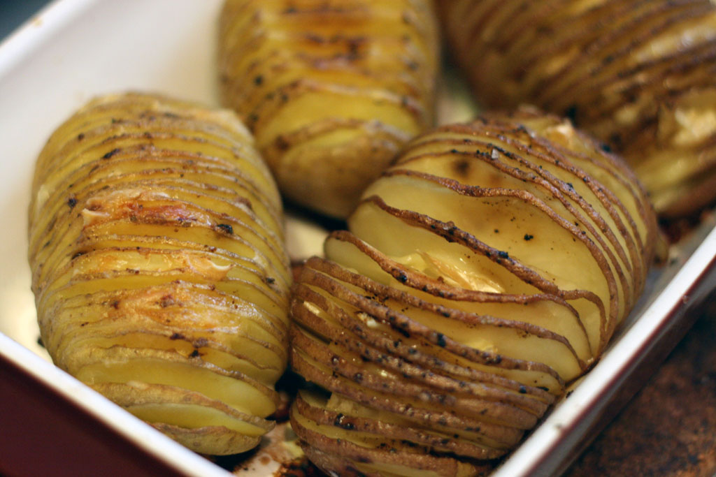Hasselback Potatoes Picture of Hasselback Potatoes from above (4 of them) in a red square serving dish.