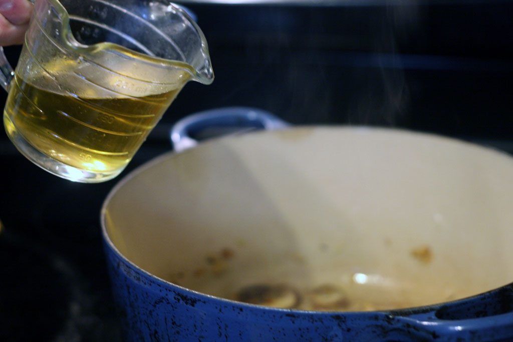 adding in white wine to the mushroom risotto