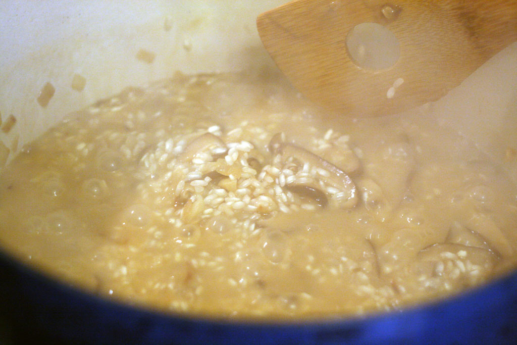 adding chicken stock to the risotto