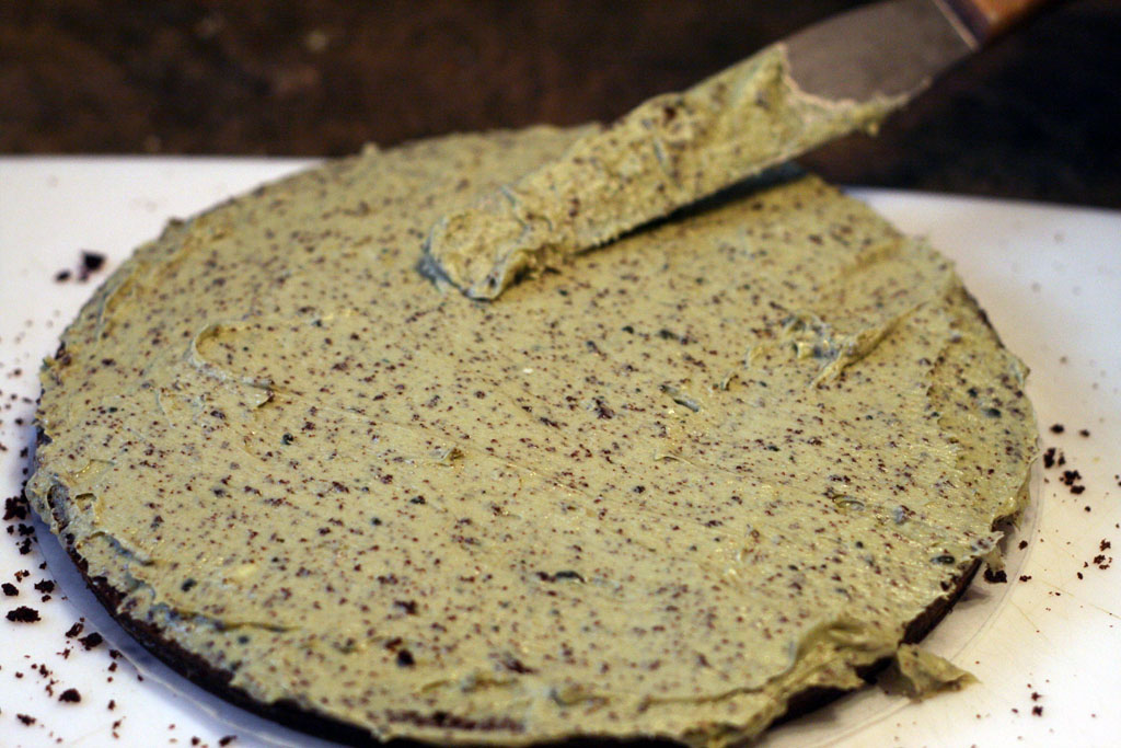 A layer of chocolate cake completely covered with matcha buttercream