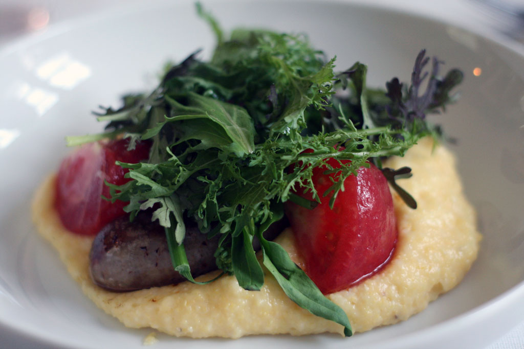 House Sausage House Sausage on a bed of Gruyere Polenta, confit tomatoes, rapini, mustard greens