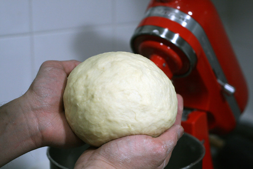 two hands holding the finished ball of dough.