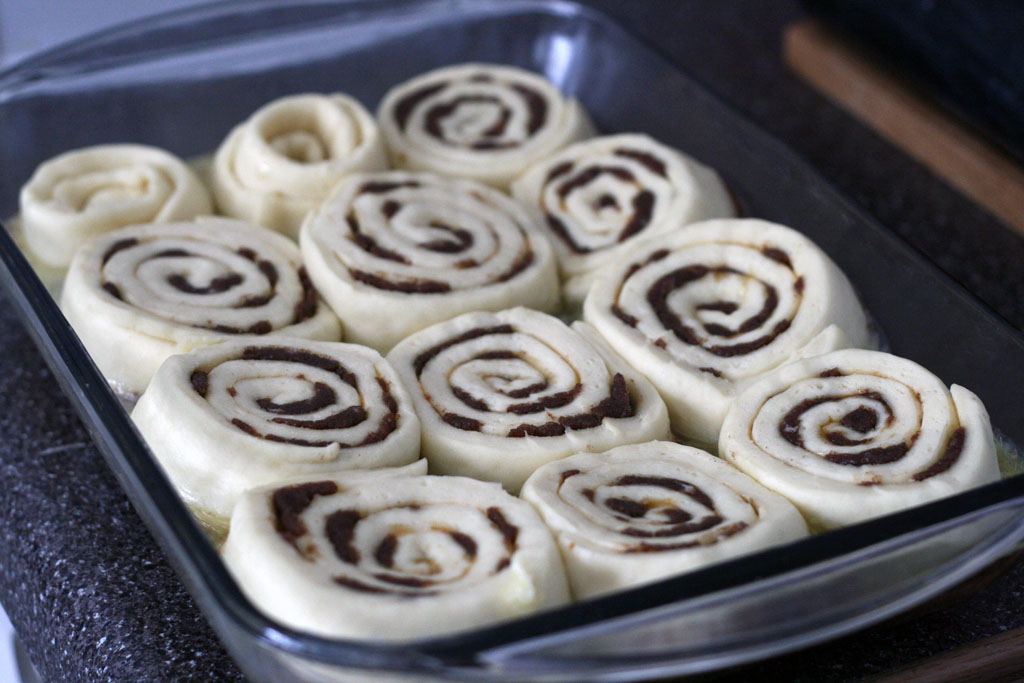 cinnamon rolls arranged into the rectangular baking dish filled with goo