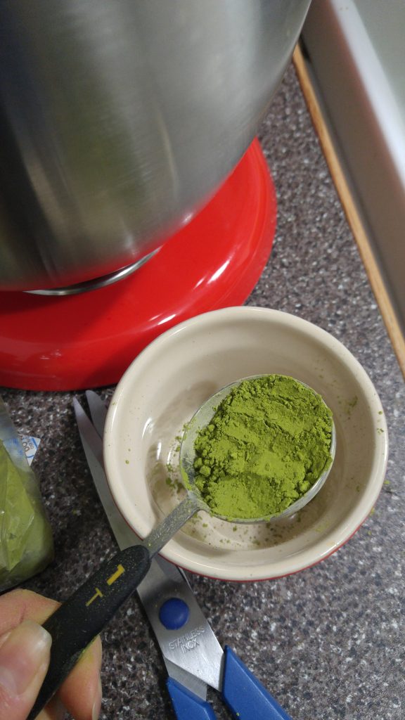 A tablespoon of green matcha tea powder.