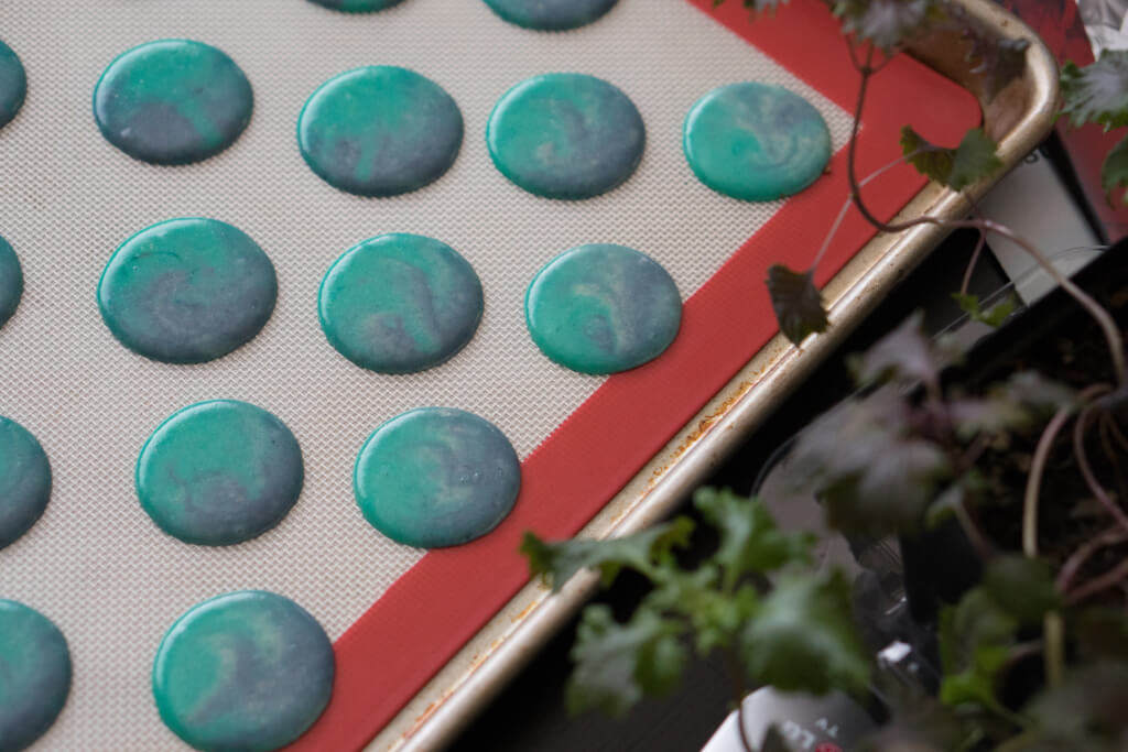 cosmic macarons piped and resting on a silpat mat