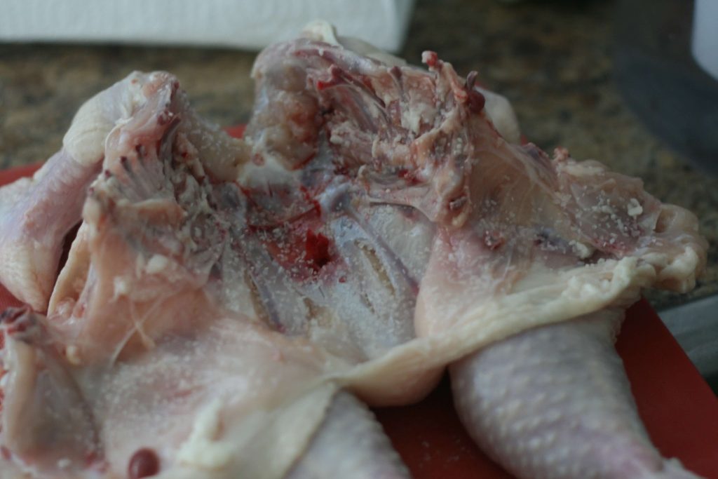 Chicken cut apart on a cutting board.