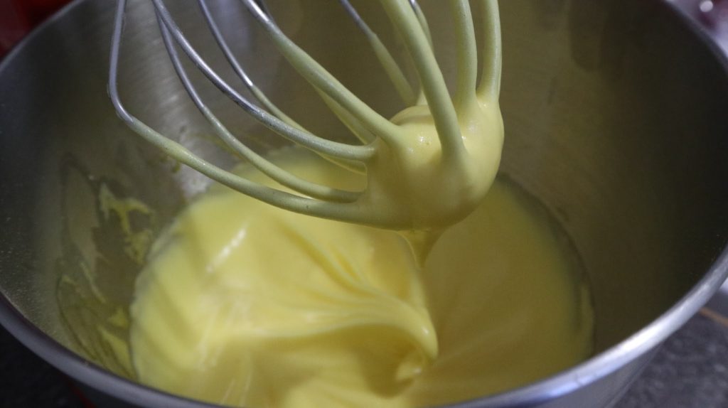 whisking the egg whites until it forms the bird's beak