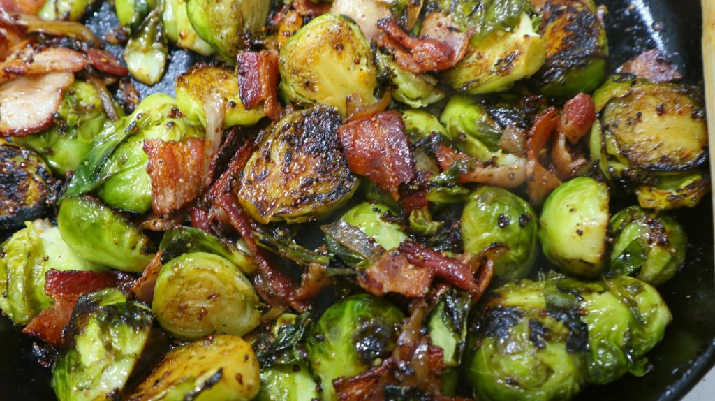 brussels sprouts and bacon all cooking in a pan