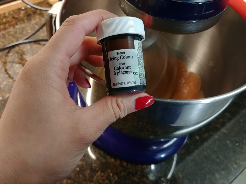 Wilton brown gel food colouring being added to the macaron mixture. 