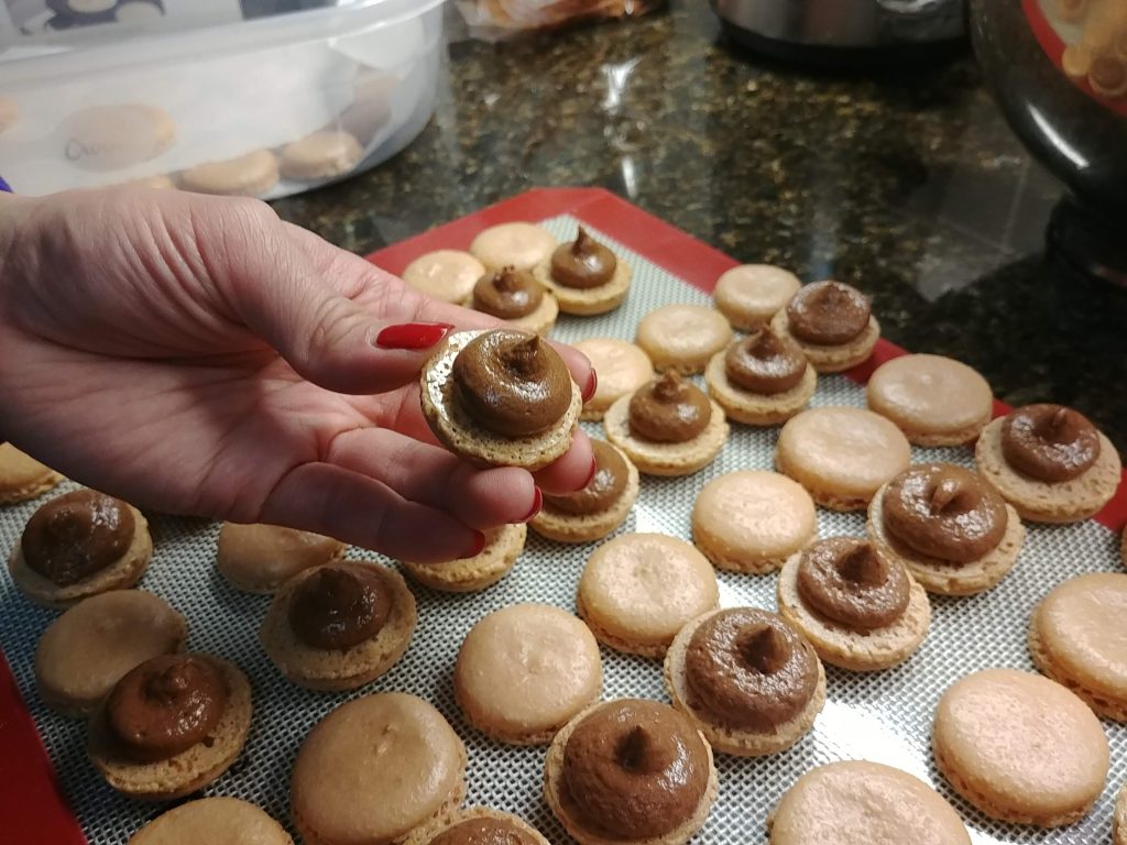 chocolate buttercream piped onto macaron shells. 