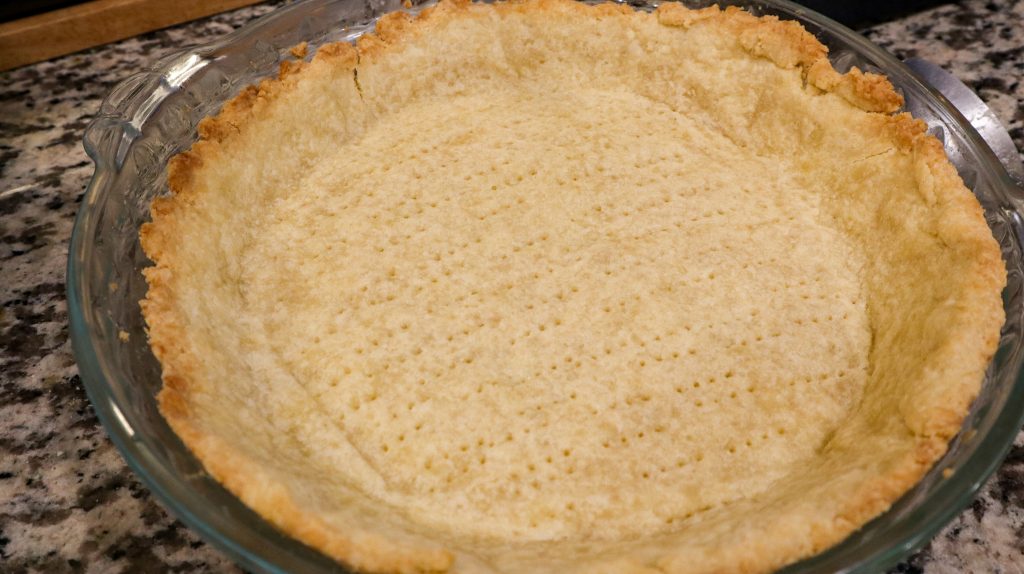 Pate sucree crust cooling in a glass pie dish